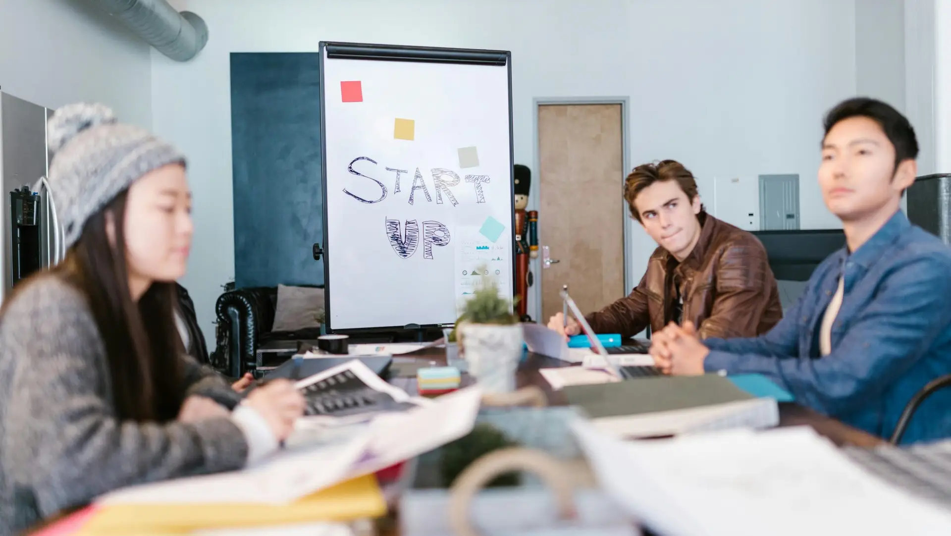 A group of young professionals brainstorming ideas in a startup office setting.
